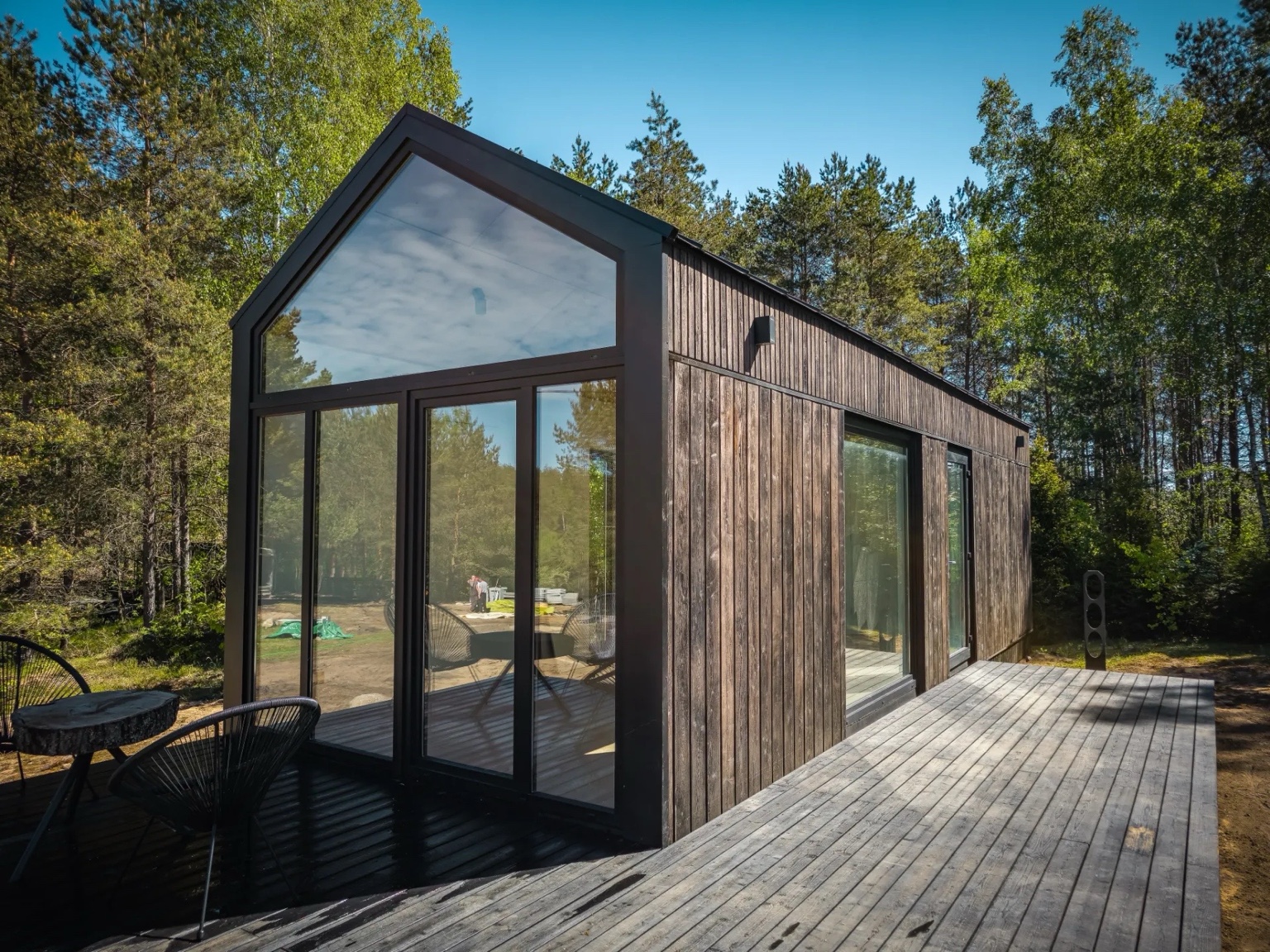 Attefallshus med träfasad, stora glaspartier och trädäck